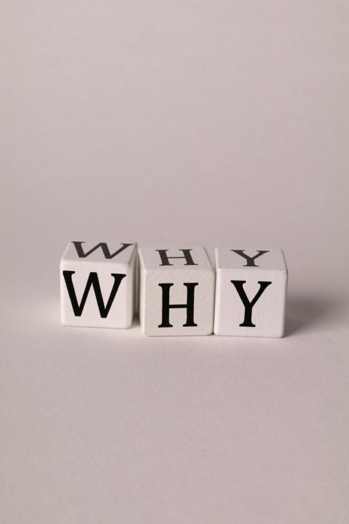 Three cubes spelling 'WHY' on a plain background, symbolizing curiosity and questioning.